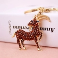 Golden goat keychain with reddish-brown rhinestones on a white book edge decoration - Coffee