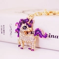 Llavero de unicornio con diamantes de imitación, acabado dorado y detalles en esmalte púrpura - Morado