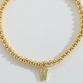 Minimalist gold beaded bracelet featuring a polished metal letter W pendant - Letter W