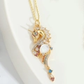 Collana con ciondolo a unicorno dorato con zirconi colorati e pietra di luna bianca - Base dorata con zircone bianco
