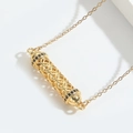 Hollow cylindrical gold necklace with intricate geometric patterns and black zircon accents - Black Zirconia