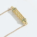 Gold hollow cylinder pendant necklace featuring intricate cross patterns and green zircons - Green Zircon