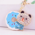Cute bear keychain with blue donut and sparkling white rhinestones on golden metal hook - Blue