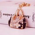 Exquisite handbag-shaped keychain with gold metal, sparkling rhinestones and floral pattern - Black