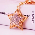 Golden star keychain with sparkling rhinestones and hollow-out design for handbags - White