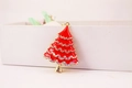 Detailed close-up of a sparkling rhinestone-studded red Christmas tree keychain pendant - Red