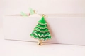 Detailed macro view of green enamel Christmas tree keychain with colorful rhinestones - Green