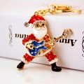 Llavero de Papá Noel rockero con diamantes rojos y una guitarra azul en metal dorado - Estilo Papá Noel con Guitarra