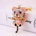 Cute golden tiger keychain with white rhinestones and pink enamel finish charms - Peach