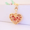 Gouden holle rozenhart sleutelhanger met roze en witte strassteentjes op witte trap - Holle Roos Hart / Roze