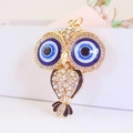 Glinsterende uil sleutelhanger met blauw boze oog ontwerp en gouden afwerking - Zwart
