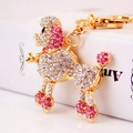 Squisito portachiavi a barboncino dorato con strass bianchi e rosa su libro bianco - Rosa