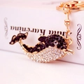Cute dolphin keychain featuring golden metal base and sparkling black rhinestones - Black