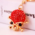 Skull keychain with red rhinestones and golden metal finish as a creative bag charm - Red