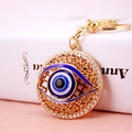 Goldener Evil Eye Schlüsselanhänger mit funkelnden Strasssteinen und filigranem Metallmuster - Himmelblau