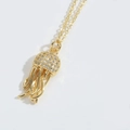 Exquisito collar con colgante de medusa dorada con micro circonitas sobre fondo gris - Medusa (Dorado)