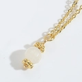 Minimalist gold necklace featuring a polished white moonstone pendant in a macro view - White Bead Style / White