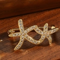 Elegante goldene Seestern-Brosche mit Kristallen auf vintage Holzoberfläche - Seestern Stil (Gold)