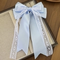 Detail van lichtblauwe satijnen strik met wit kant en lange linten in een geschenkdoos - Lange Lint Kant Stijl (3#)