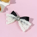 Détail d'une pince à cheveux avec nœud en dentelle et centre luxueux en strass brillant - Noir