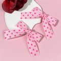 Close-up of pink bow hair clips with heart prints on a white decorative stone plate - 4#