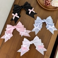Elegant satin bow hair clips in four pastel colors on a rustic wooden surface with roses - Four-Piece Set