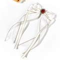Détail du nœud en satin blanc avec pierre rouge et bords brodés de fils dorés - Blanc
