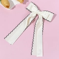 Detalle de elegante pinza para el pelo con doble lazo crema y cinta de encaje bordada - Beige