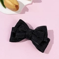 Dettaglio ravvicinato di un fermaglio per capelli in pizzo nero con ricami floreali a strati - Piccolo Fiocco Nero