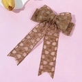 Macro detail of bronze lace bow hair clip with intricate floral embroidery on pink surface - Bronze Brown Long Ribbon Bow