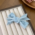 Macro shot of light blue velvet bow hair clip with elegant double-layered texture - Blue