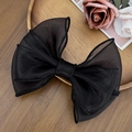 Vista detallada de un lazo grande de organza negra con diseño de malla en capas - Negro