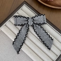 Dettaglio dell'elegante fermaglio per capelli a fiocco in tweed grigio con bordo nero - Coda lunga / Grigio (4#)