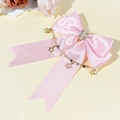 Dettaglio fiocco in raso rosa con catenine a stella dorate e centro di perle e strass - Rosa