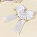Dettaglio di fiocco in raso bianco con perla, strass e ciondoli a catena di stelle - Bianco