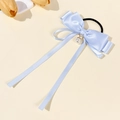 Details von hellblauer Satin-Schleife mit Perlenanhänger und langen fließenden Bändern - Blau