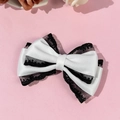 Detail of white satin hair bow with black lace trim and multi-layer elegant design - White