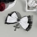 Detail of gothic bow hair clip with black lace, heart gemstone, and silver cross pendant - White