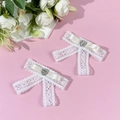 Detailed close-up of white lace bow hair clips with heart-shaped rhinestone centers - Beige (1 Pair)