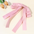 Detalle de lazo para el cabello en satén rosa con cintas largas y textura de seda elegante - Rosa