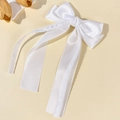 Detail of white satin bow hair clip featuring delicate lace edges and long flowing ribbons - White
