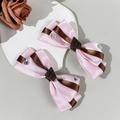 Makro-Detail von Lolita-Haarschleifen mit Schokoladenanhängern und Herz-Strasssteinen - Rosa