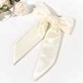 Detailed macro view of the cream satin bow hair clip showing smooth texture and elegant ribbon - Beige