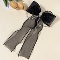 Dettaglio di un fermaglio per capelli in tulle nero con catene di perle e decori in cristallo - Nero