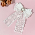 Detalle del lazo de encaje blanco con pedrería central y elegantes cintas largas - Blanco