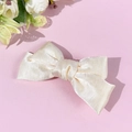 Close-up of elegant cream satin double-layered bow hair clip with glossy silk texture - Beige