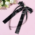 Cerchietto con fiocco a pois neri decorato con perle e strass su sfondo rosa pastello - Nero