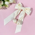 Elegante witte satijnen haarclip met lange linten en tulp hanger op een roze achtergrond - Beige