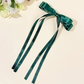 Dettaglio del fermaglio a fiocco in raso verde scuro con bordi dorati e nastri - Verde Scuro
