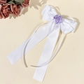 Detalle de un lazo de satén blanco con una delicada rosa lavanda y largas cintas elegantes - Blanco